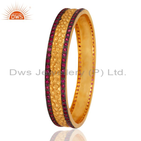 Supplier of 18k yellow gold plated ruby color white zircon textured bangle