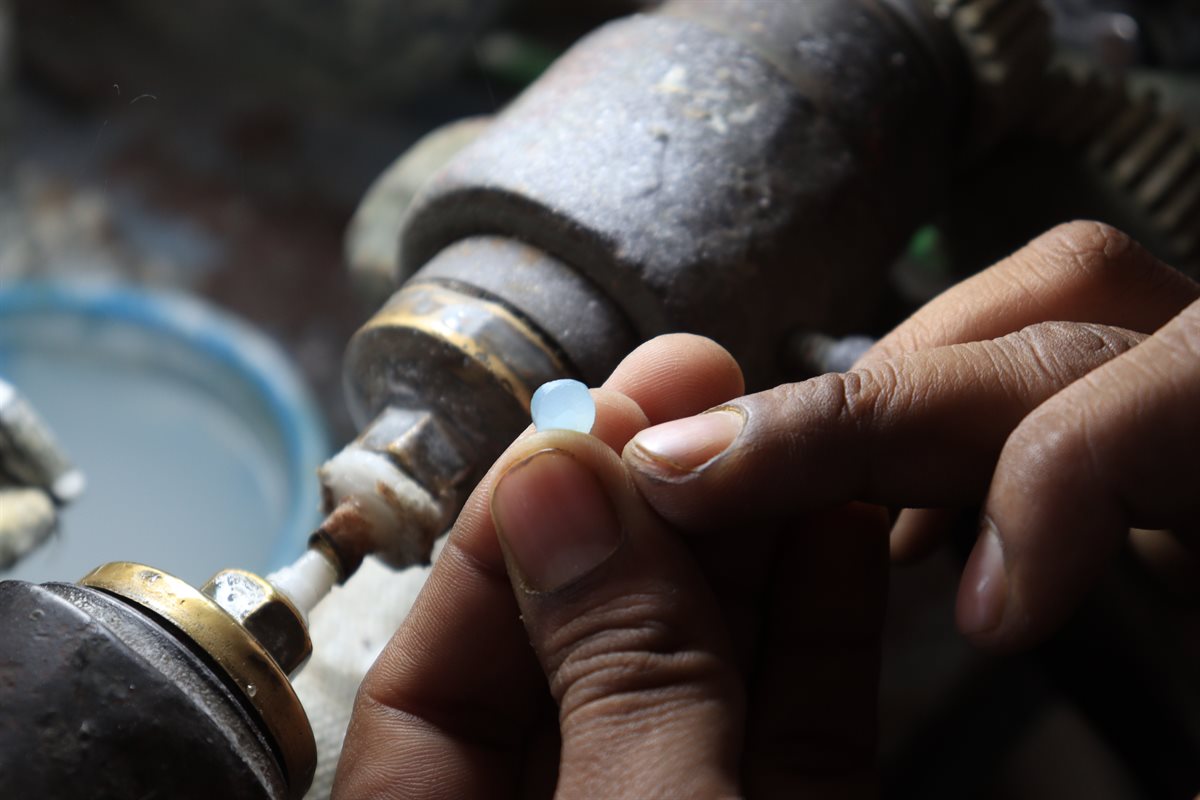 Shaping a gemstone on a special-tool machine at DWS Jewellery, Jaipur